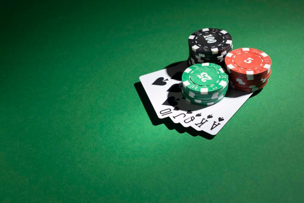 fichas-de-casino-apiladas-y-escalera-real-sobre-fondo-verde
